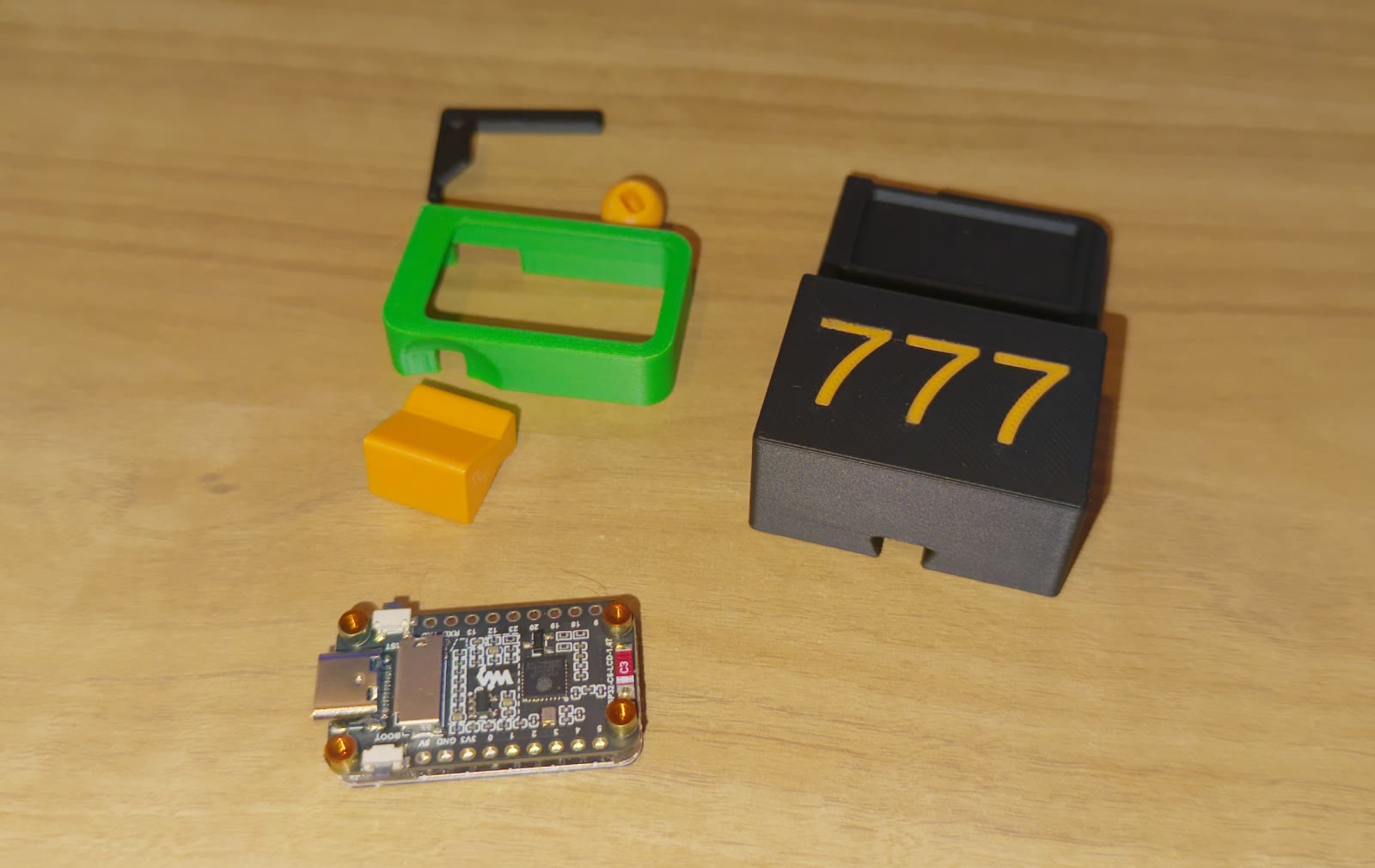 The five printed parts and the ESP32-C6 board laid out on a desk
